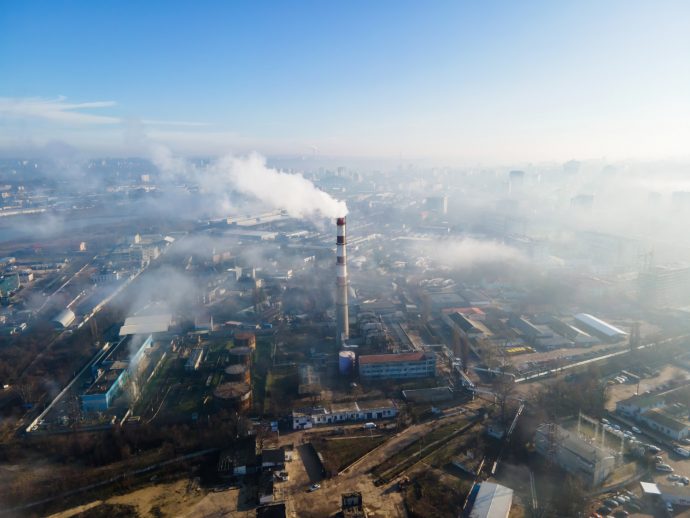 Aerial drone view chisinau thermal station with smoke coming out tube buildings roads fog air moldova